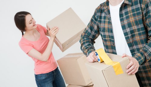 Movers carrying furniture through a Brixton flat staircase
