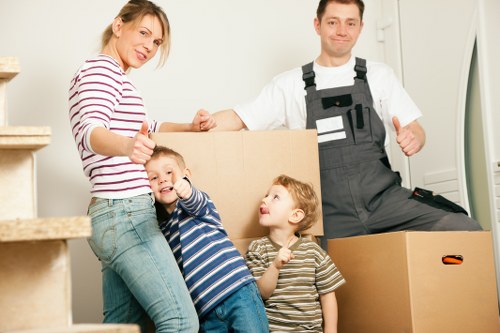 Movers carrying furniture through a Brixton flat with narrow access
